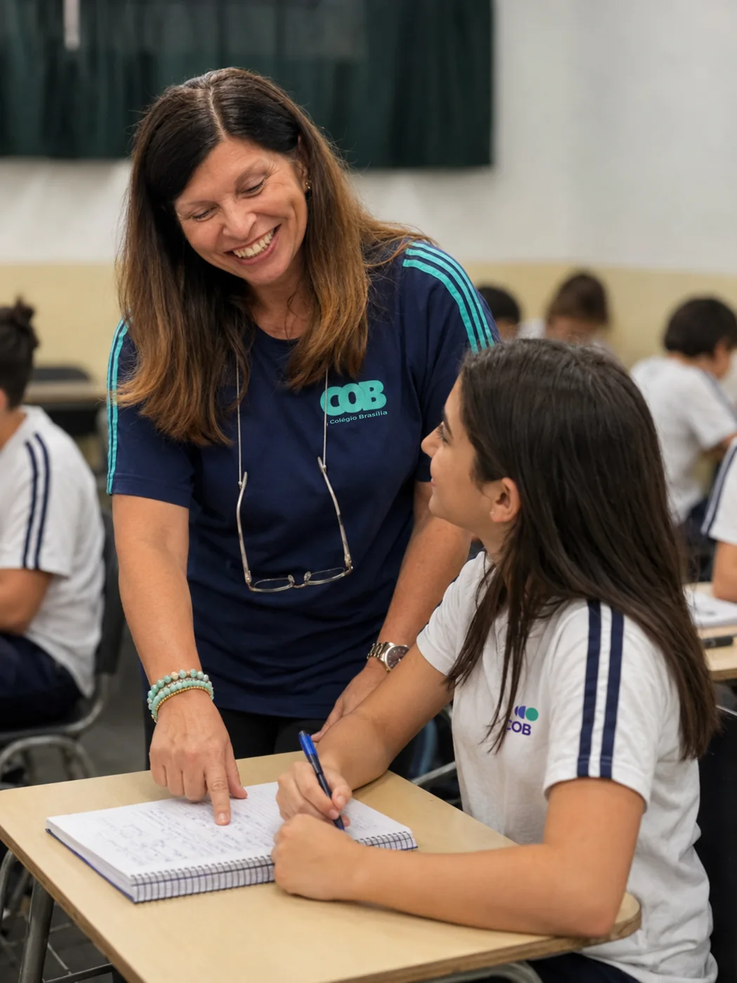 Professora acompanhando aluna em atividade na unidade Diadema do Colégio COB